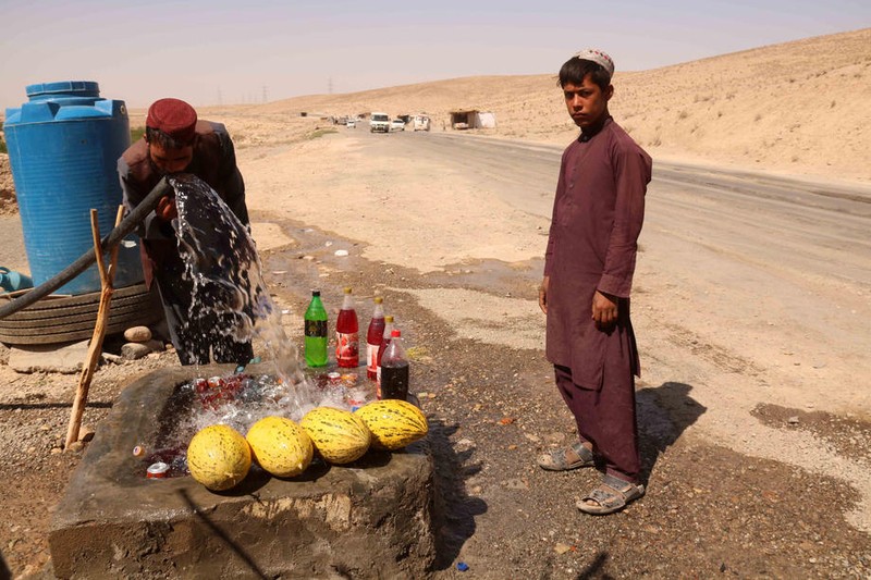 Afgani care vând pepeni la marginea autostrăzii Kabul-Kandahar Foto: EPA-EFE/AKHTER GULFAM
