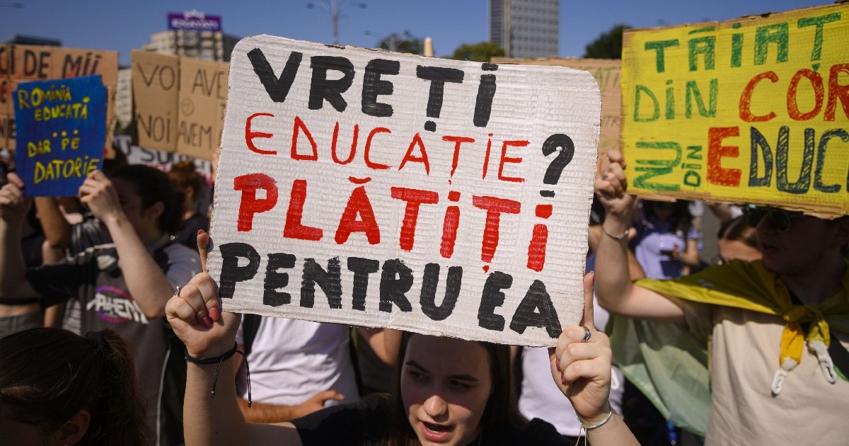 Tineri afiseaza pancarte in timpul unui protest organizat de Alianta Nationala a Organizatiilor Studentesti din Romania (ANOSR) impotriva reducerii fondurilor pentru burse, in fata Guvernului, in Piata Victoriei din Bucuresti, joi, 26 iunie 2025