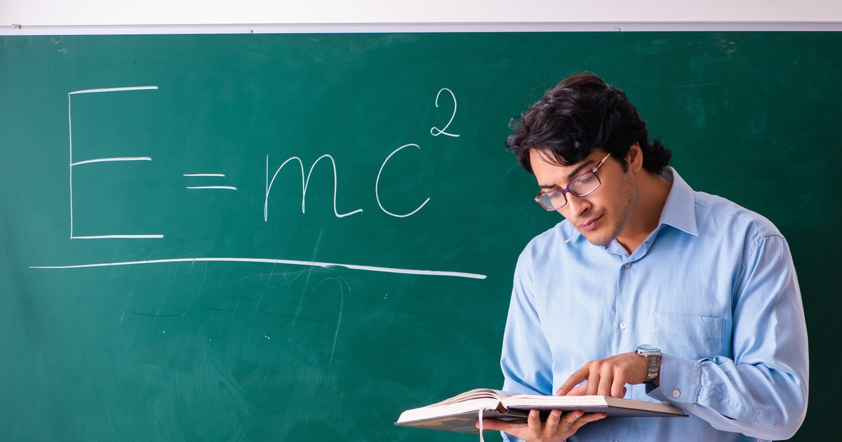 Profesor în cămașă la tablă, unde este scrisă ecuația E=mc2 din fizică