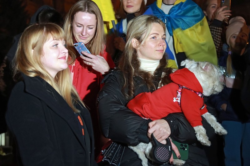 Tinere, una dintre ele cu un animal de companie, în centrul Kievului, alături de oamenii care sărbătoresc eliberarea Hersonului. | Foto: Profimedia