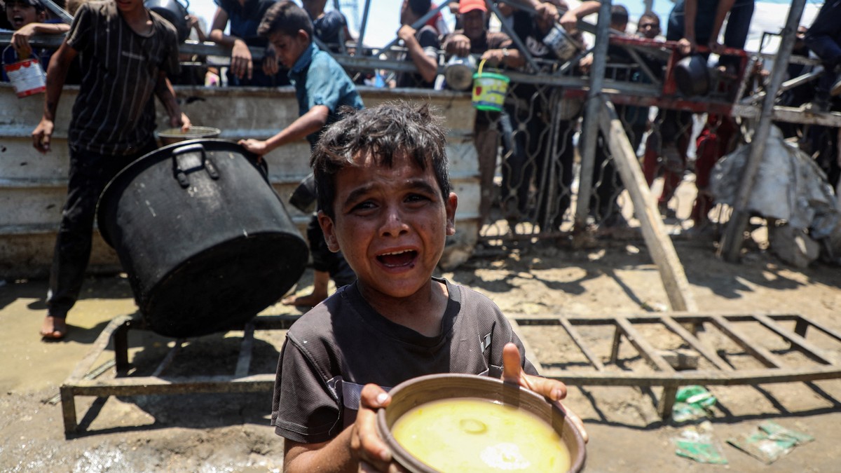 Imagine cu un copil care ține în mâini un bol cu mâncare, în Gaza.