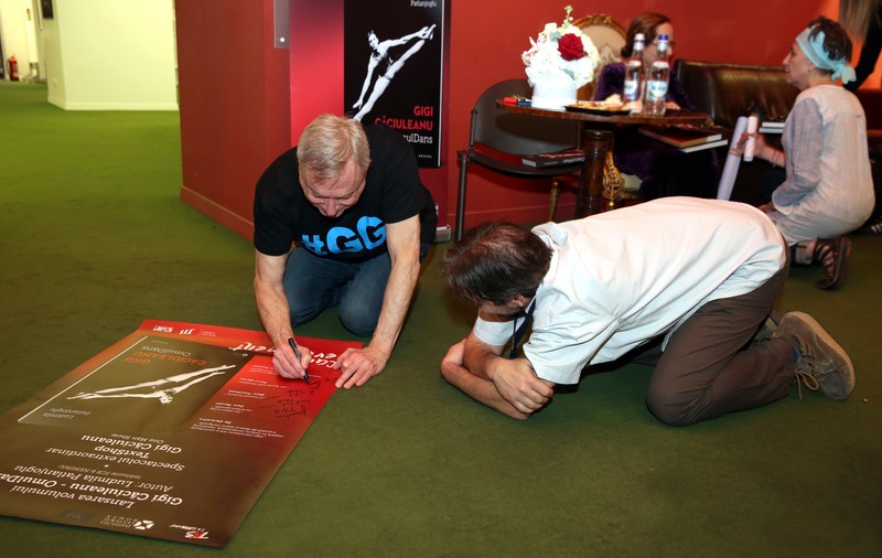 Gigi Căciuleanu a dat autografe desculț, stând în genunchi și a scos la licitație poezii scrise de el