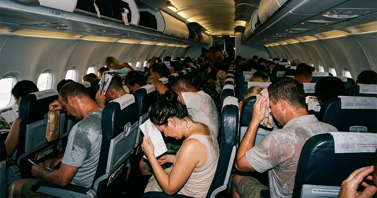 Pasagerii unui avion transpirați din cauza căldurii insuportabile din avion.