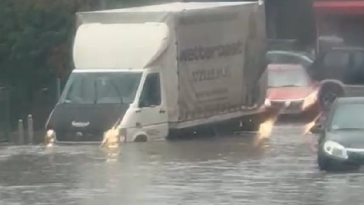 Mai multe mașini pe o șosea inundată.