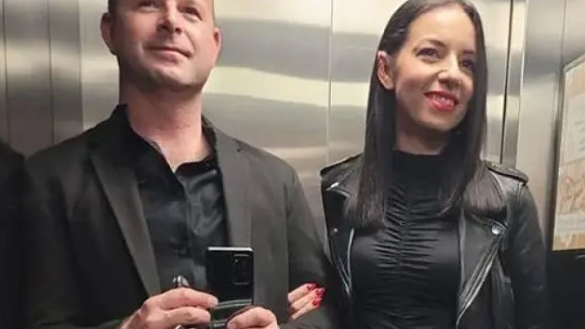 Josip și Monika Sincek, foografiați într-un lift, zâmbind. Bărbatul are un smarphone în mâini