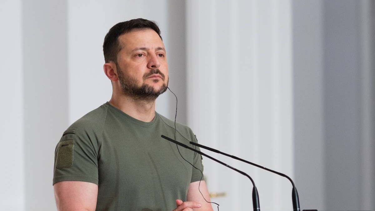 Președintele Ucrainei, Volodimir Zelenski, îmbrăcat cu un tricou verde, în fața unui pupitru cu microfon