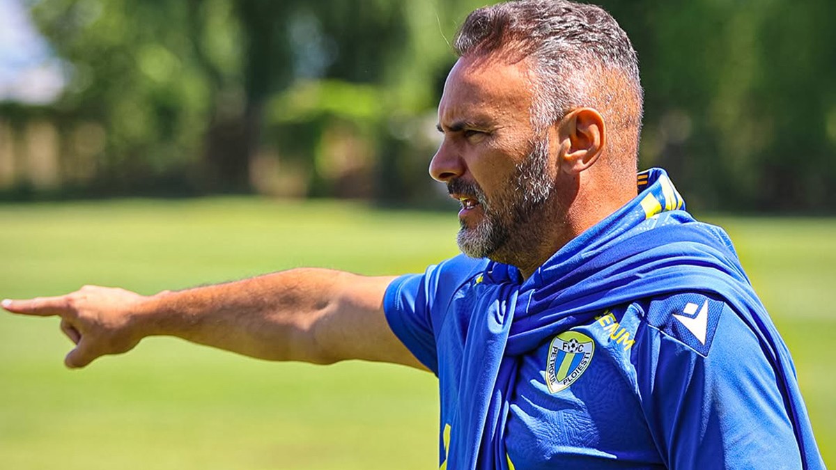Ricardo Sousa îmbrăcat în tricoul echipei Ploiști arată cu degetul în dreapta.
