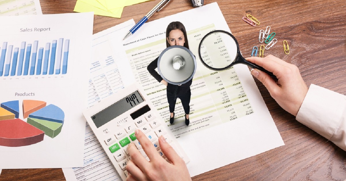 Ce este loud budgeting, tendința financiară populară la generația Z - Imagine cu o femeie, în miniatură, cu portavoce aşezată pe o factură, lâgă un calculator de birou
