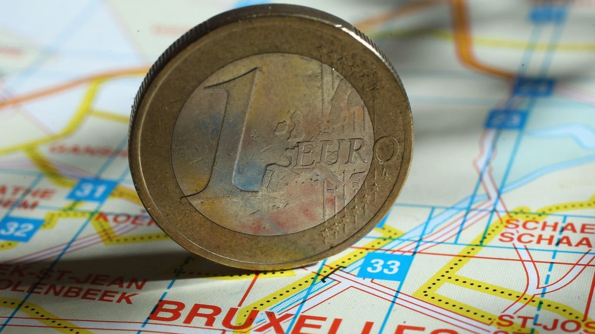 o monedă de un euro este plasată pe o hartă a Bruxelles-ului, la 9 decembrie 2011, în Berlin, Germania