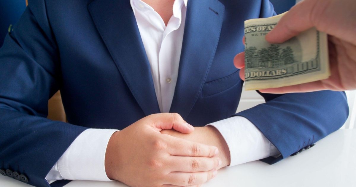 magine în prim-plan a unei persoane care oferă mită