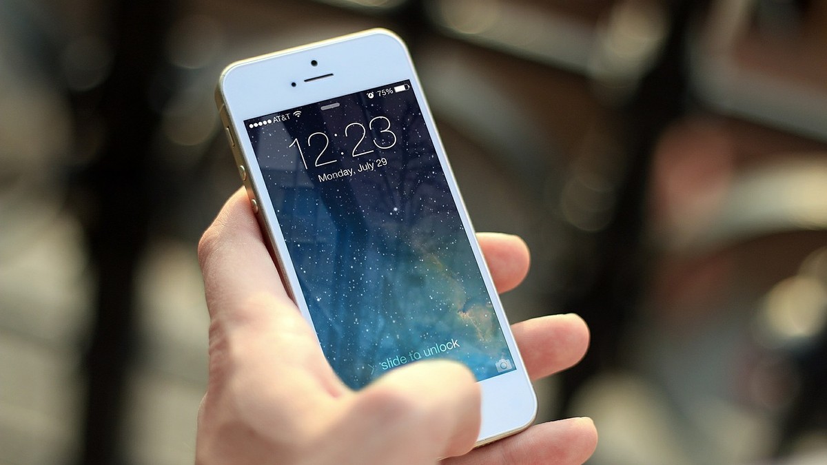 Apple vrea să lanseze un ”Netflix pentru știri”. iPhone 8 alb, ținut în mână
