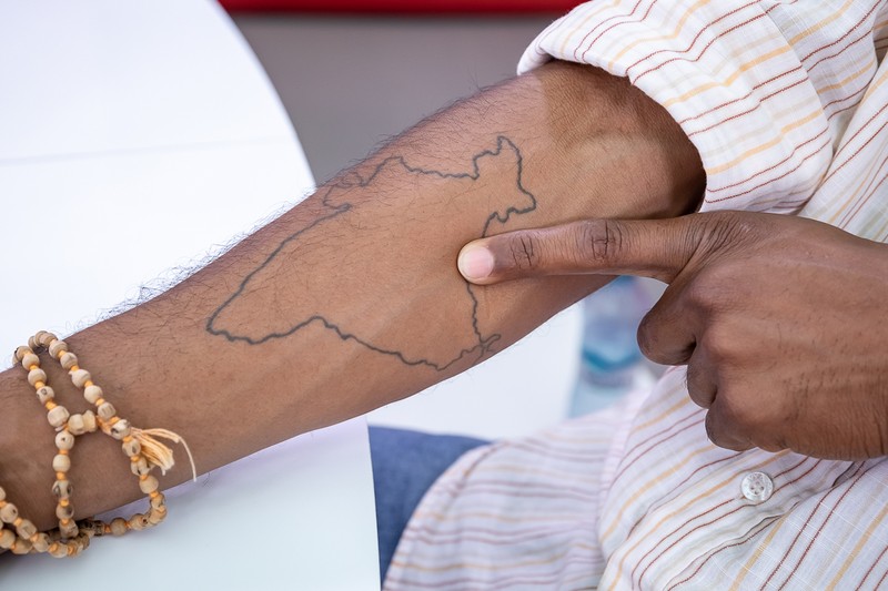 Hitesh arată unde se află satul său pe harta Indiei tatuată pe braţ