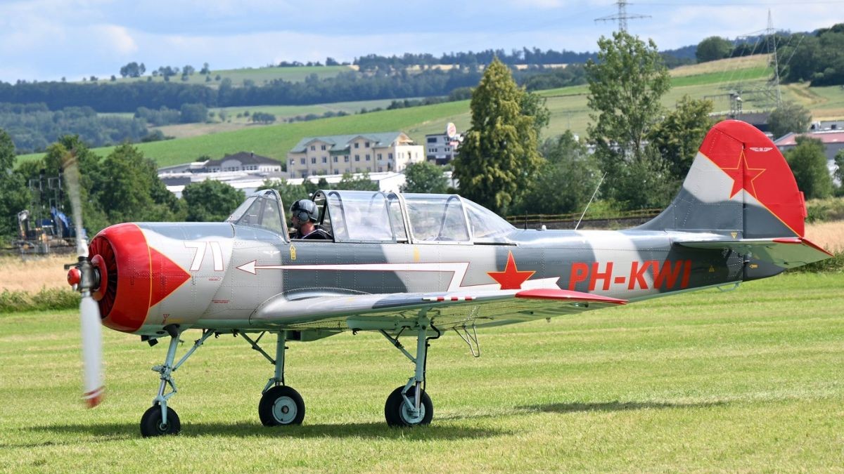 Un avion YAK-52 cu o elice este pregătit să decoleze de pe un câmp, iunie 2024