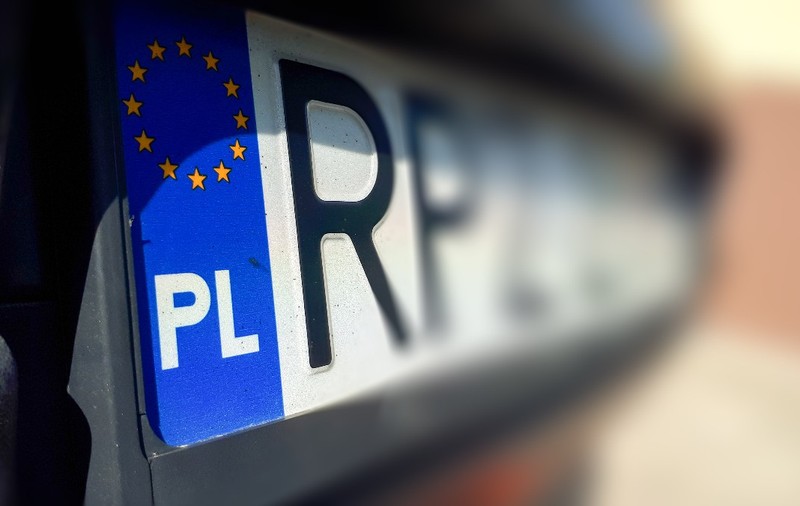 O plăcuță de înmatriculare auto din Polonia, evidențiind banda albastră din stânga cu drapelul Uniunii Europene și sigla „PL”.