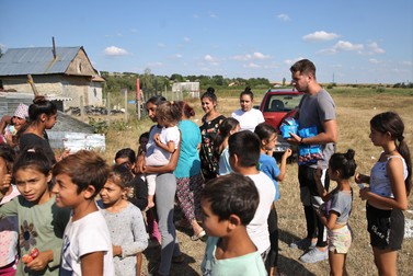Copiii din suburbia Negreştiului aşteaptă să primească bomboane de la voluntari