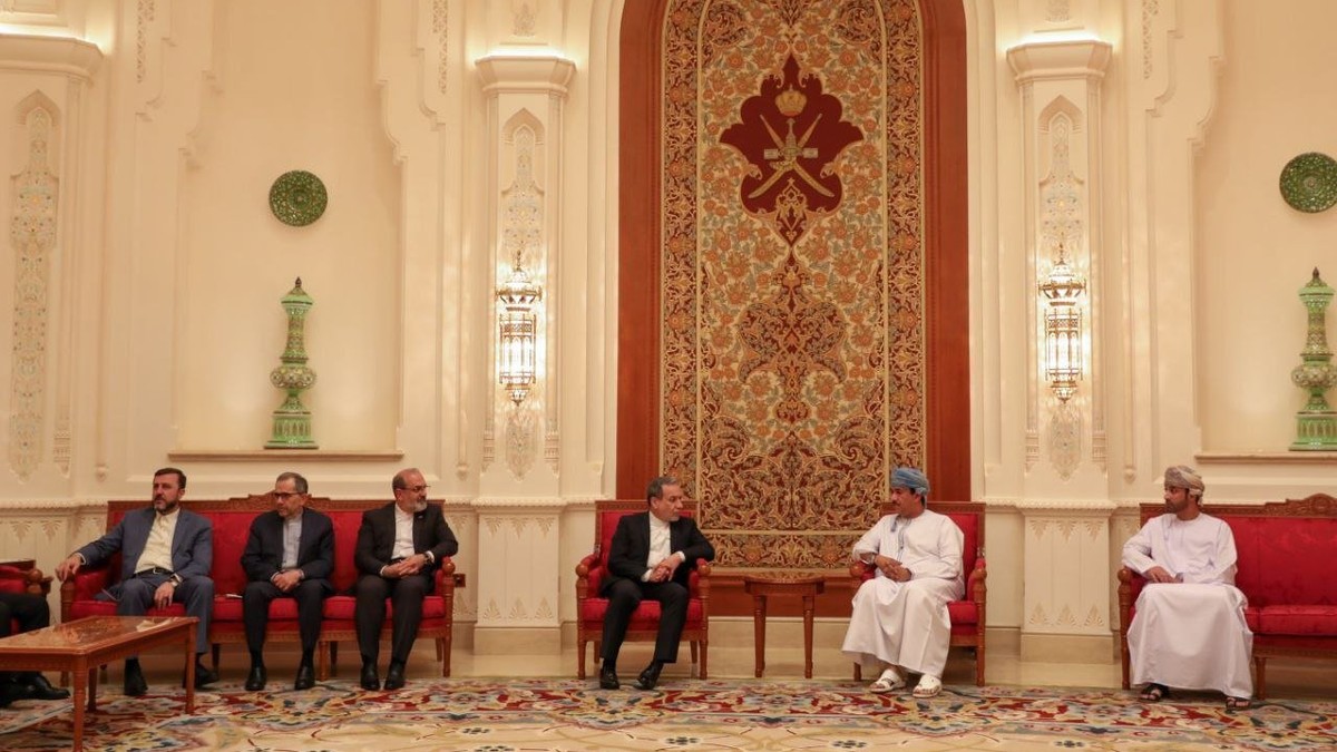 Ministrul iranian de externe, Abbas Araghchi (centru), discută cu un oficial omanez neidentificat la sosirea sa la Muscat, înainte de negocierile cu trimisul american pentru Orientul Mijlociu, Steve Witkoff