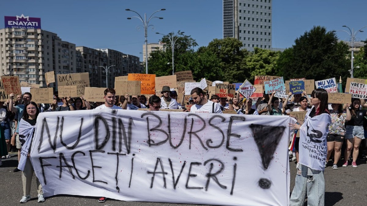 Mai mulți tineri țin pancarte în mâini în timpul unui protest al studenților din Bucuresti, 26 iunie 2025
