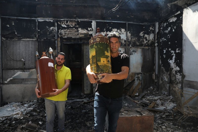 Rezidenți evrei din Lod, salvând scroluri Tora dintr-o sinagogă incendiată FOTO: EPA