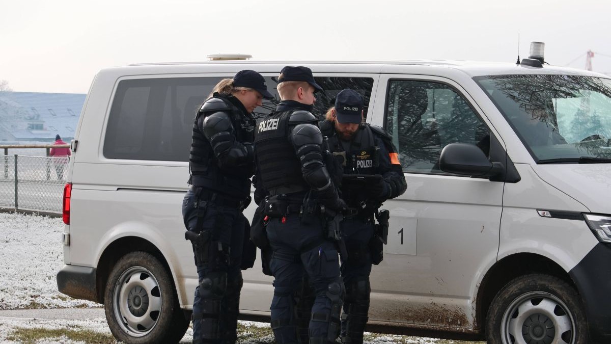 Trei polițiști se consultă în fața unei autospeciale în Rümlang, Elveția, 21 ianuarie 2026