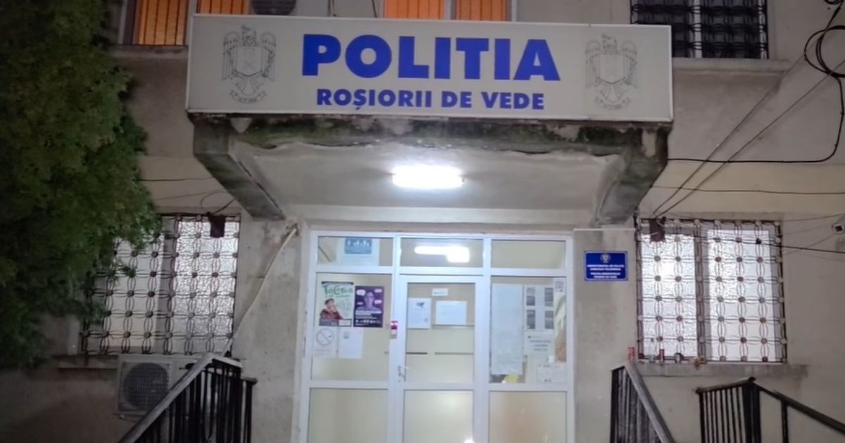 Sediul Poliției din Roșiorii de Vede, pe timp de noapte, cu o ușă albă de termopan la intrare