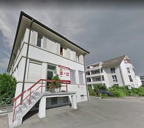 Așa arată sediul firmei din Elveția, iar pe fundal este blocul în care locuiește administratorul Roland Konrad Schmelzle