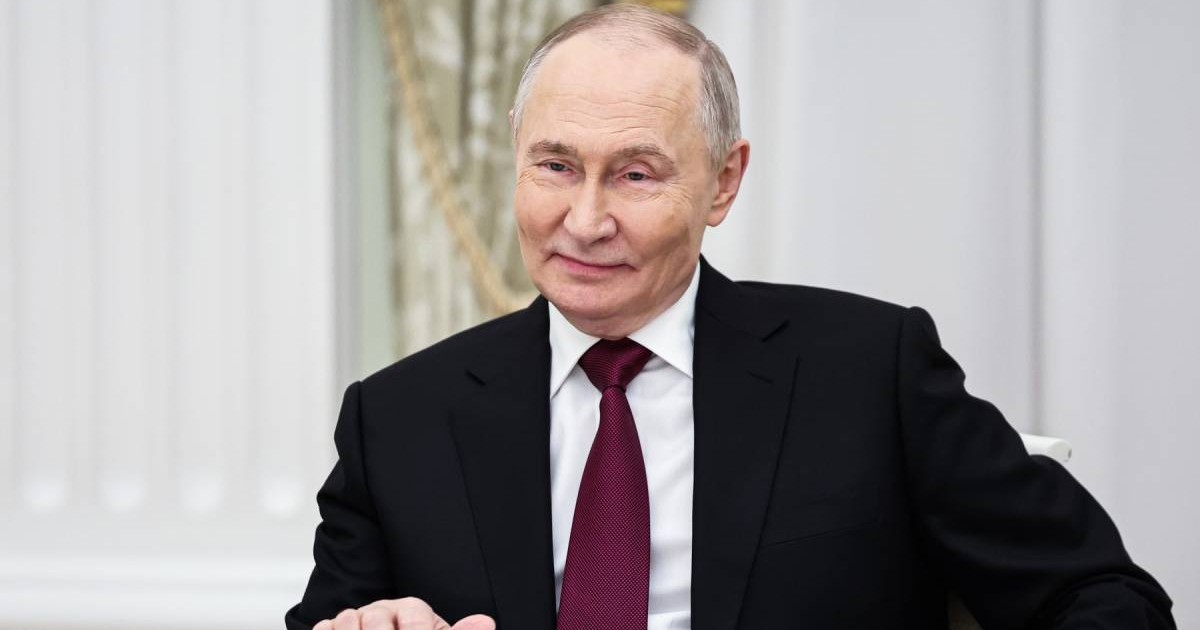 Vladimir Putin , surprins zambind, in sacou negru si cravata grena, camasa alba, în timpul discuției cu Steve Witkoff, trimisul prezidențial special al SUA, la Kremlinul din Moscova, 2 decembrie 2025