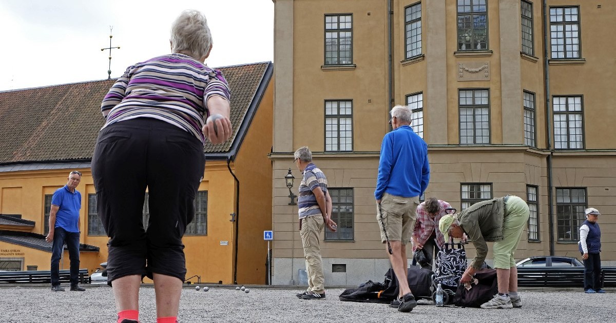 Oameni de difeite vârste în curtea interioara a unei clădiri din Suedia, Stockholm.