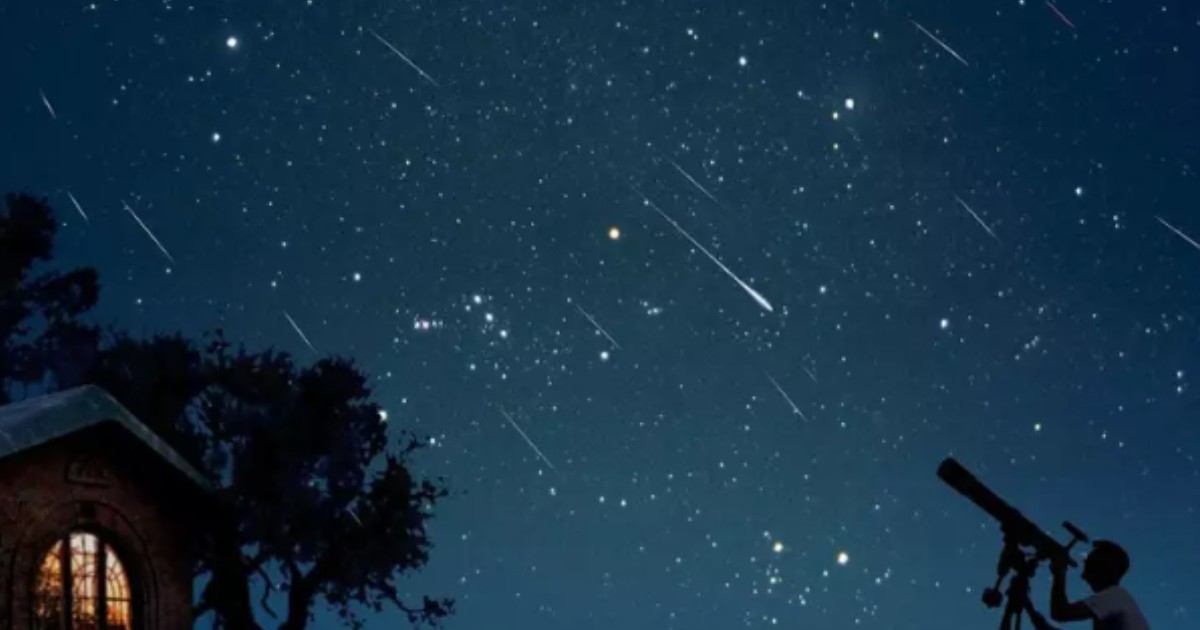 Un bărbat care folosește un telescop și privește o ploaie de meteori