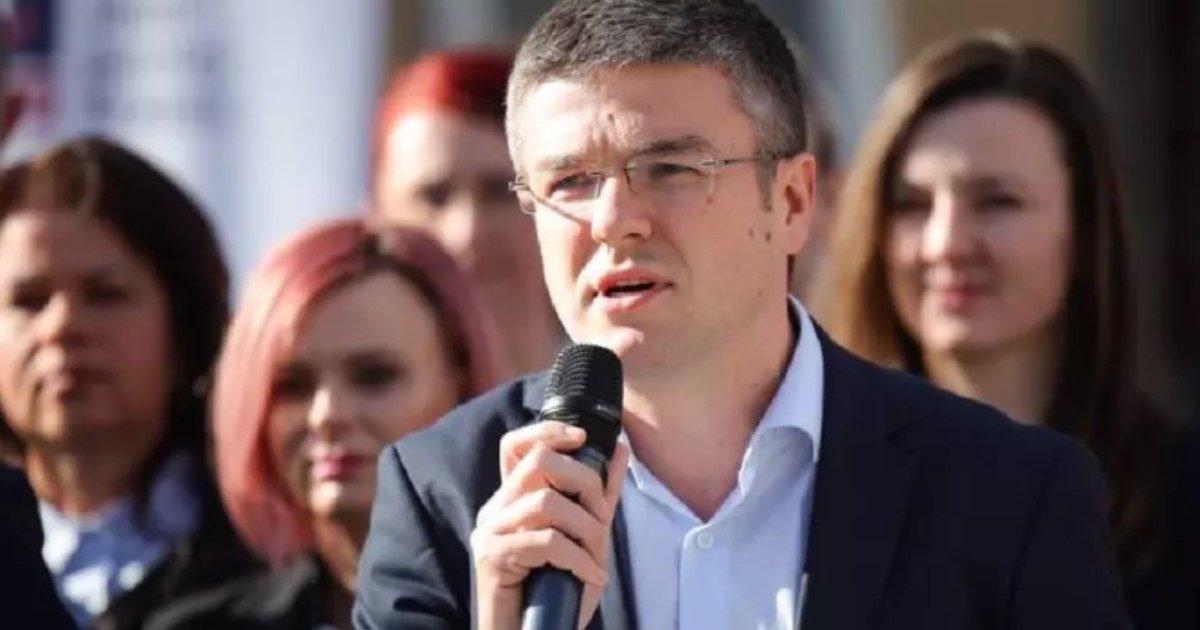 Irineu Darău în costum negru în timp ce vorbește la microfon.