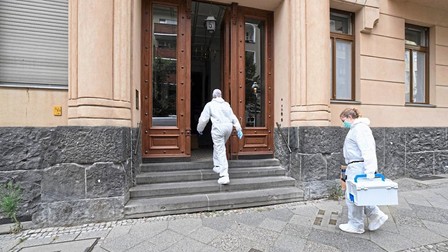 Criminaliști intrând în clădirea în care a avut loc crima. Foto: Bild