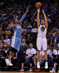 epa05014993 Golden State Warriors guard Klay Thompson (R) shoots as Denver Nuggets guard Randy Foye (L) defends during the second half of their NBA game at Oracle Arena in Oakland, California, USA, 06 November 2015. The Warriors defeated the Nuggets 119-104. EPA/JOHN G. MABANGLO CORBIS OUT