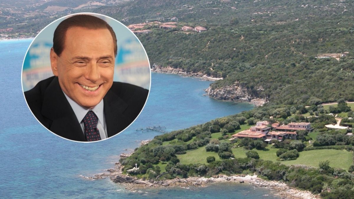 Imagine aeriană cu Villa Certosa din Sardinia și Marea Mediterană, iar într-o oglindă apare Silvio Berlusconi, îmbrăcat cu costum negru, cămașă și cravată, în timp ce zâmbește