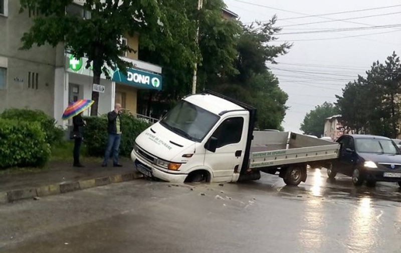 O camionetă a căzut într-o groapă din cauza ploii care a surpat șoseaua