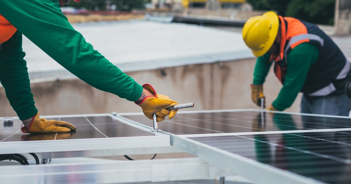 Muncitori care asambleaza panouri fotovoltaice