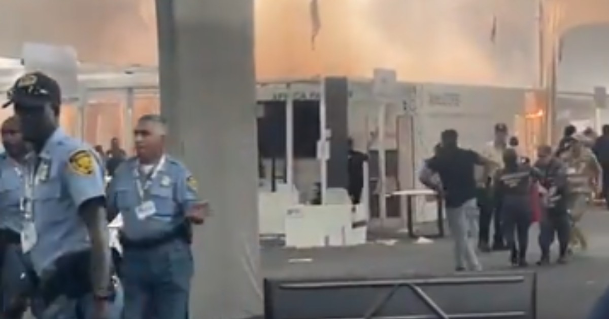Un incendiu într-un spațiu interior. În fundal se află mai mulți oameni care aleargă, iar în prim plan se află polițiști.