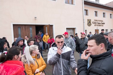 Zeci de locuitori ai comunei Ditrău vorbesc în fața căminului cultural după terminarea adunării sătești