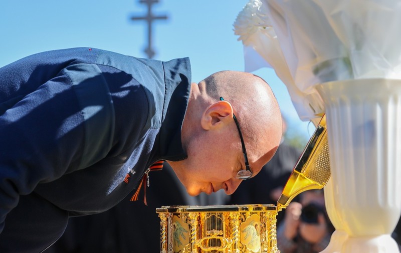 Segrhei Kirienko, omul care se ocupă de politicile lui Putin, se închină în fața unei cutii cu mâna dreaptă a lui Dmitri Donskoi, adusă pe front pentru a fi „venerată” de soldații ruși Sursa foto: Profimedia