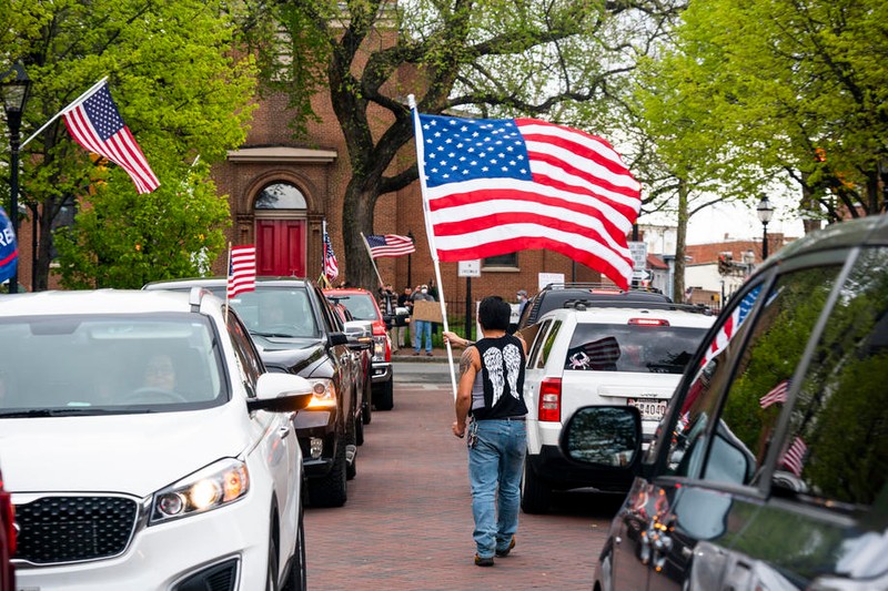 Un protestatar din statul Maryland flutură steagul SUA