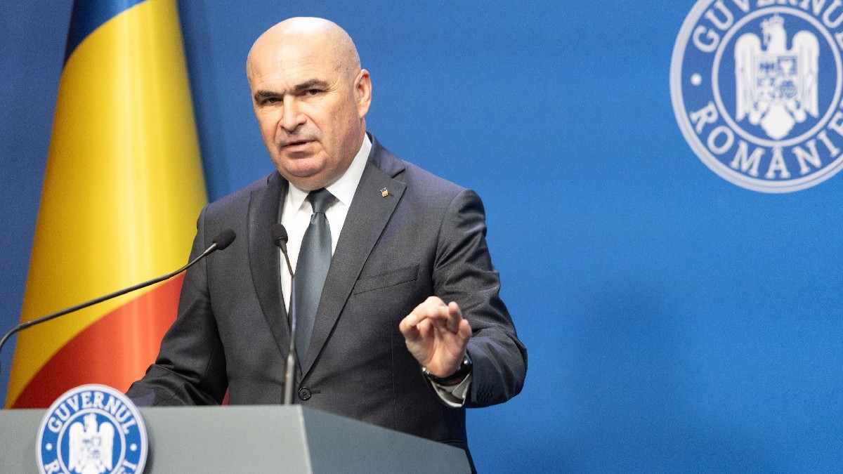 Premierul Ilie Bolojan sustine o conferinta de presa in cadrul careia prezinta pachetul de masuri privind reforma administraţiei publice locale,vineri, 18 iulie 2025, in Bucuresti. In stânga se vede steagul României