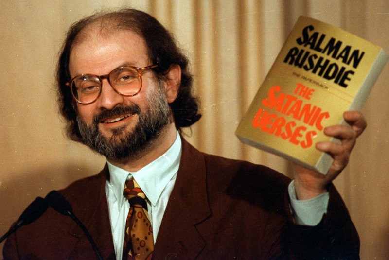Scriitorul Salman Rushdie ține în mână un exemplar al controversatei sale cărți, "Versetele satanice", în timpul unei conferințe de presă din 1992, în Arlington (foto Profimedia)