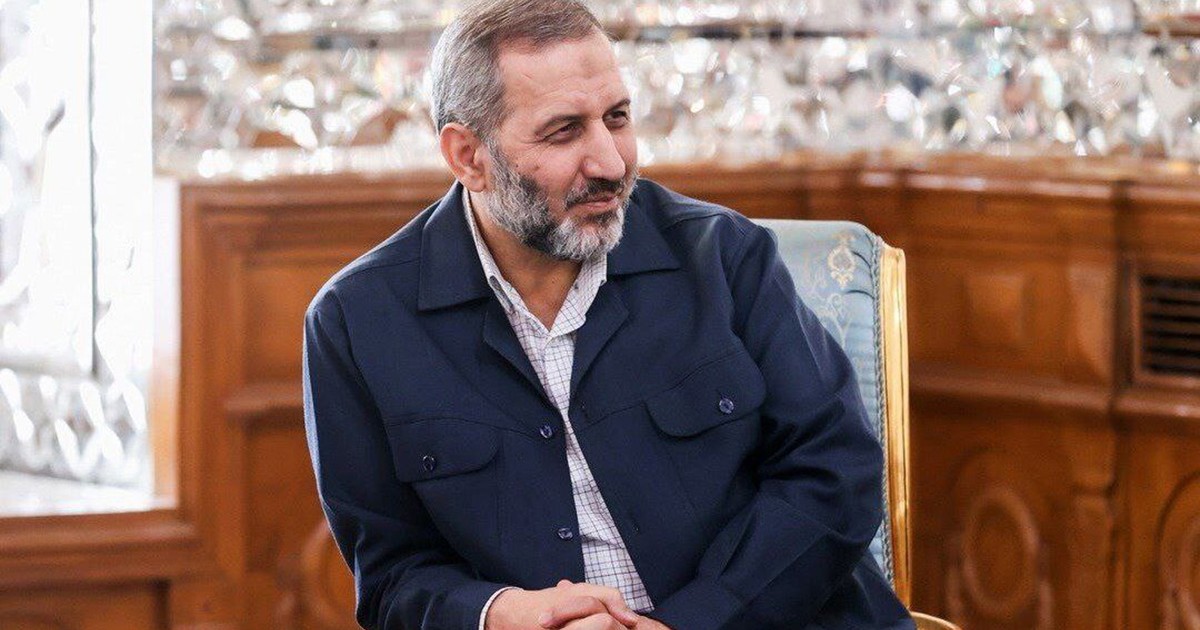 Majid Mousavi stă pe un fotoliu și zâmbește cu mâinile împreunate.