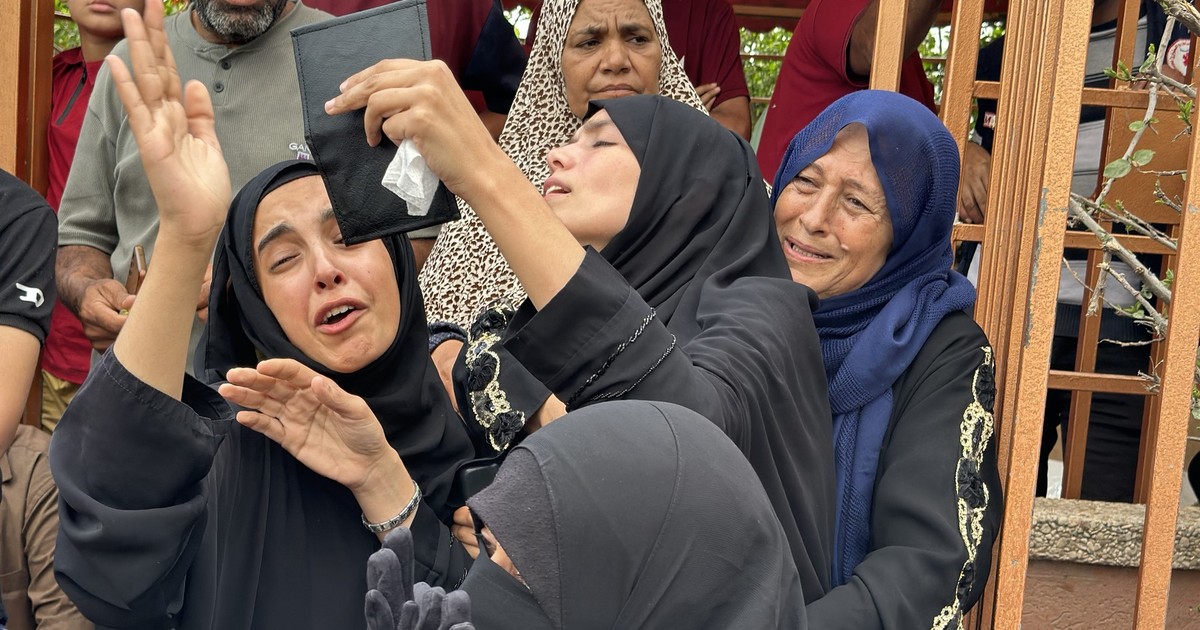Patru femei surprinse în timp ce plâng pierderea celor dragi, în urma atacului lansat de armata israeliană asupra civililor care încercau să obțină mâncare