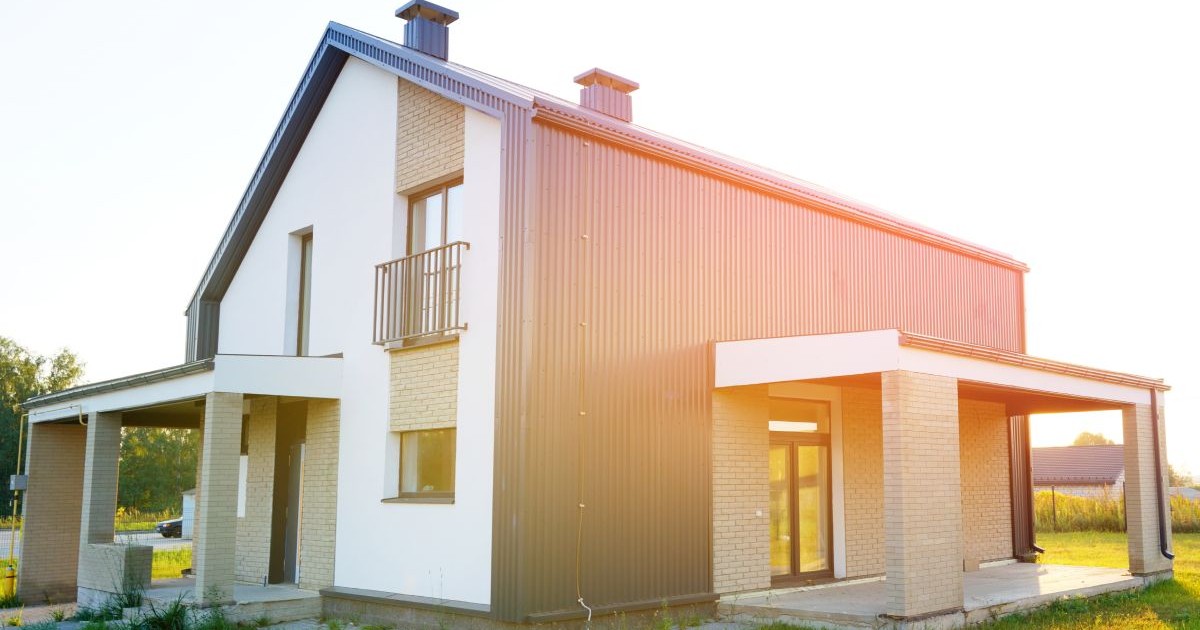 Casă cu etaj, construită din elemente prefabricate, cu soarele care bate pe acoperiș