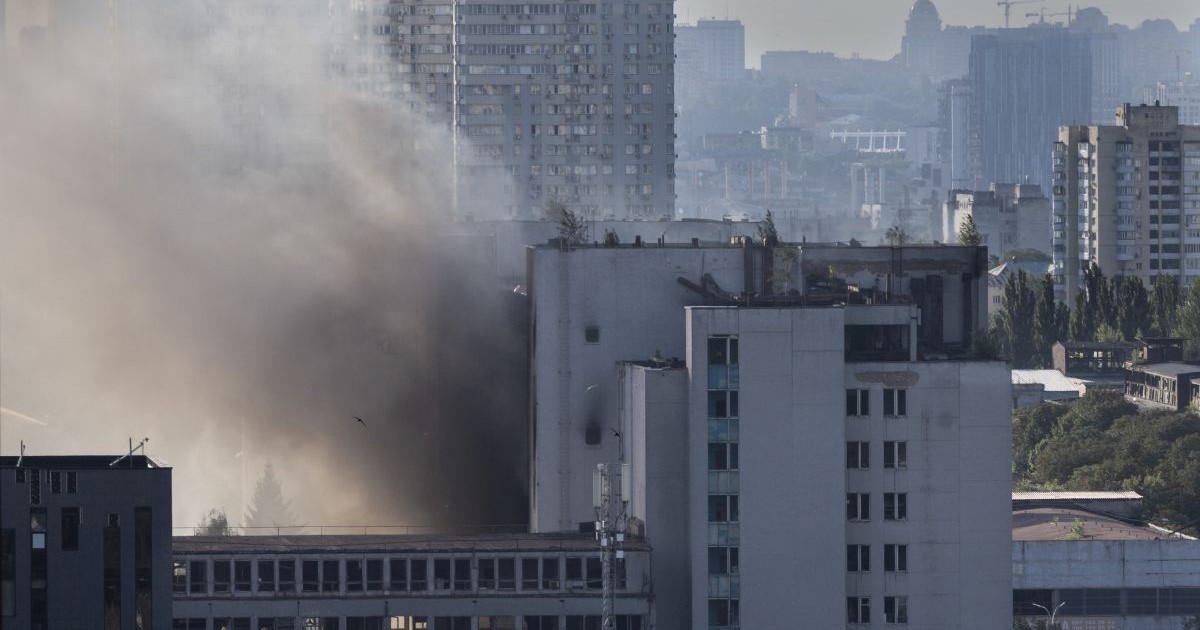 Un fum gros se ridică dintre mai multe clădiri înalte din Kiev, în urma unui atac aerian rusesc, 19 iulie 2026