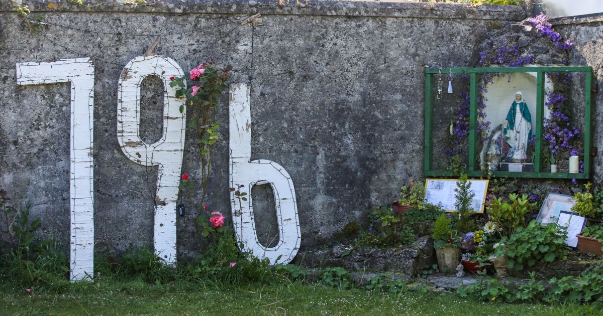 Numărul 796 reliefat prin culoare albă, pe gardul de piatră al căminului pentru mame singure din Irlanda, în luna iunie 2025