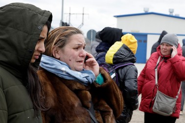O femeie din Ucraina vorbește la telefon cu soțul care a fost nevoit să rămână în Odesa în timp ce se află la punctul de trecere din Palanca, Republica Moldova, pe 13 martie 2022. Foto: EPA
