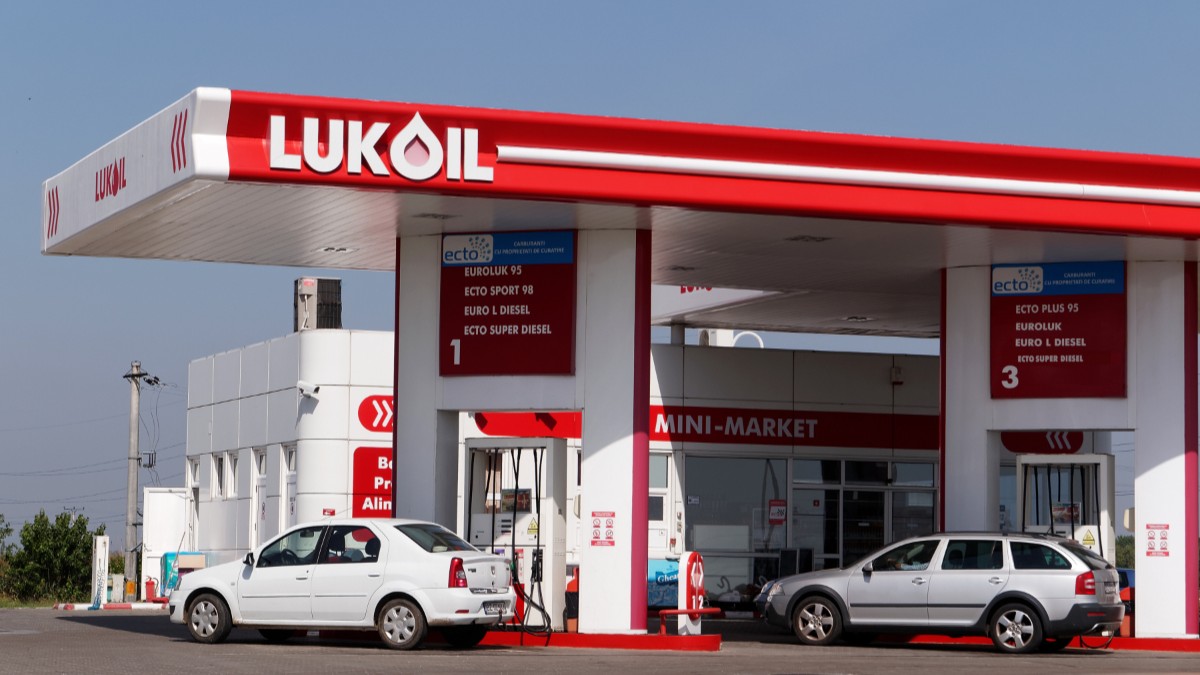 O benzinărie Lukoil din România, mașinile sunt așezate la pompă și șoferii alimentează