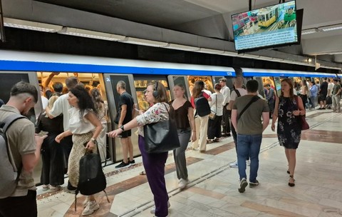 Zeci de oameni care stau pe peronul unei stații de metrou din București 