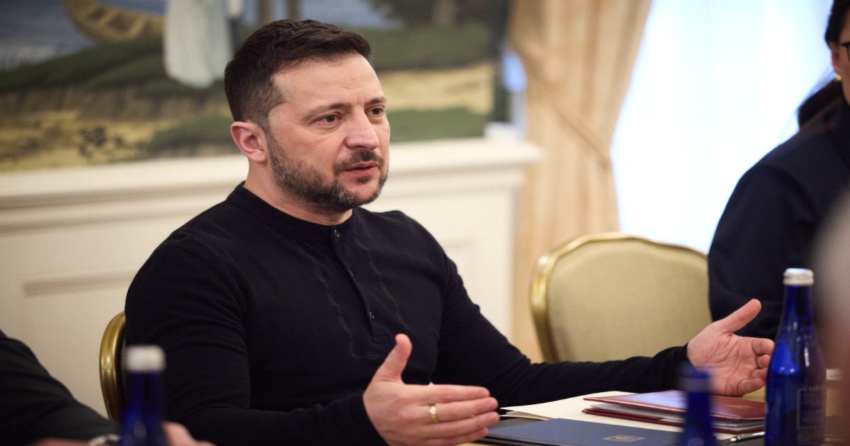 Președintele ucrainean Volodimir Zelenski stă la o masă și explică ceva cu mâna