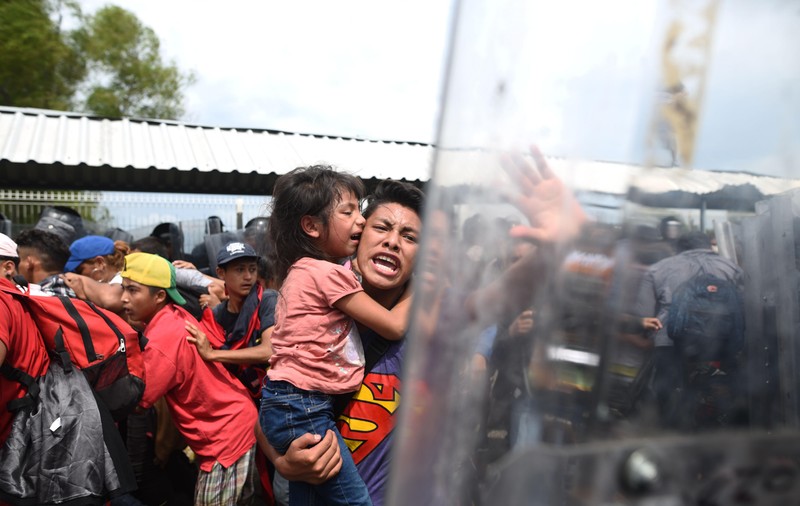 FOTO și VIDEO | Mii de imigranți se îndreaptă spre SUA. Lupte cu forțele de ordine la granița dintre Guatemala şi Mexic